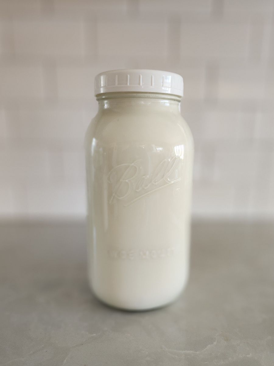 Fresh goat milk in a wide-mouth mason jar before freezing
