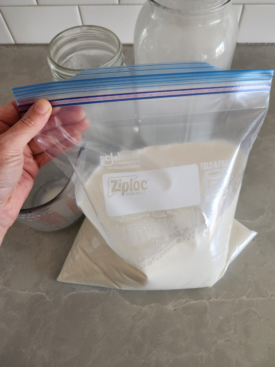 Goat milk poured into a freezer-safe plastic bag for freezing