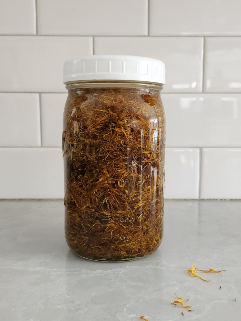 a mason jar filled with dried alendula flowers and olive oil