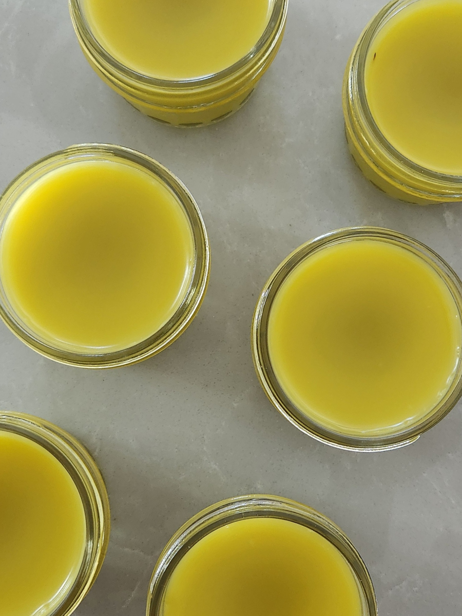 Freshly poured calendula salve cooling in glass jars — golden, soothing, and perfect for dry skin care.