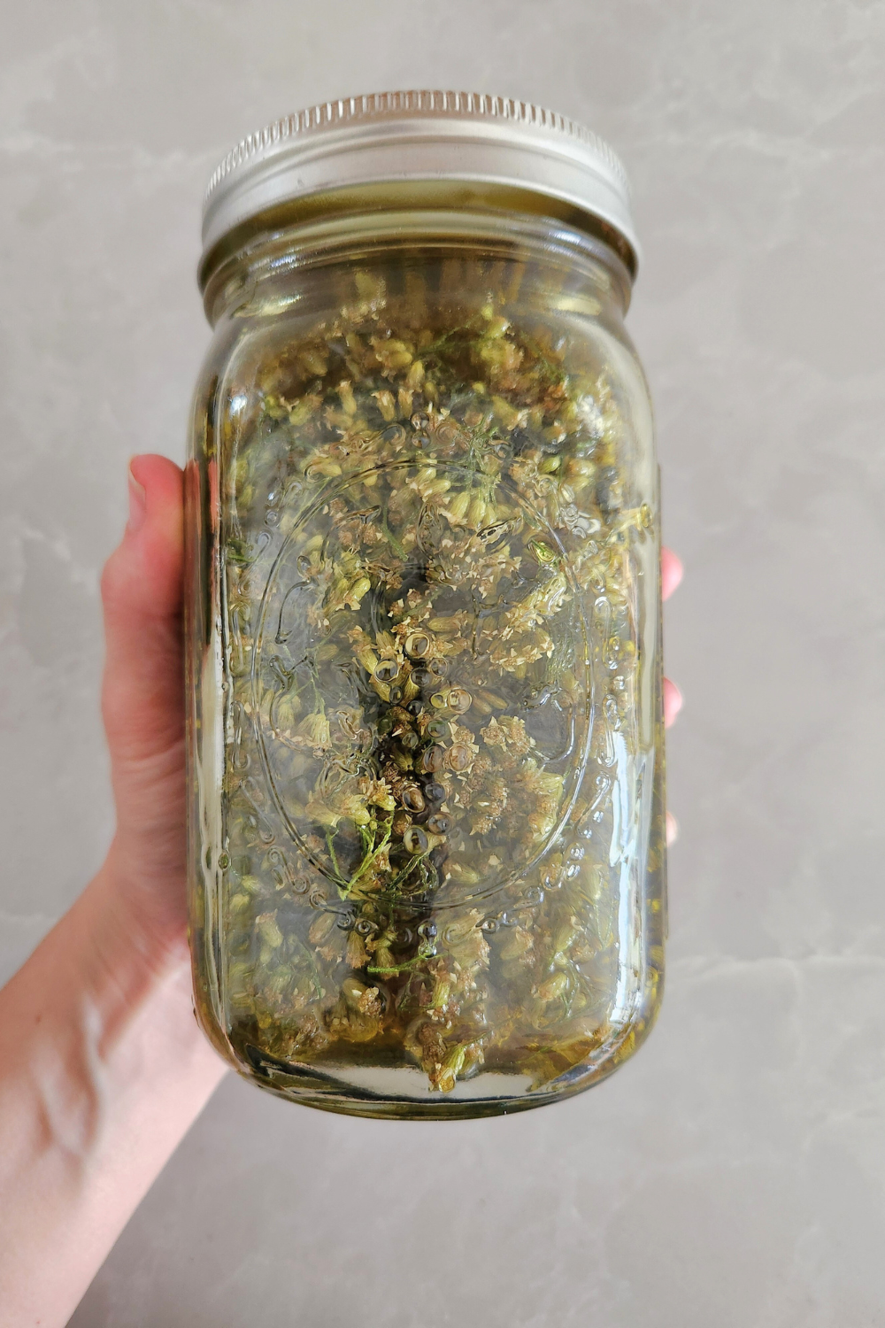 dried flowers in oil in glass jar