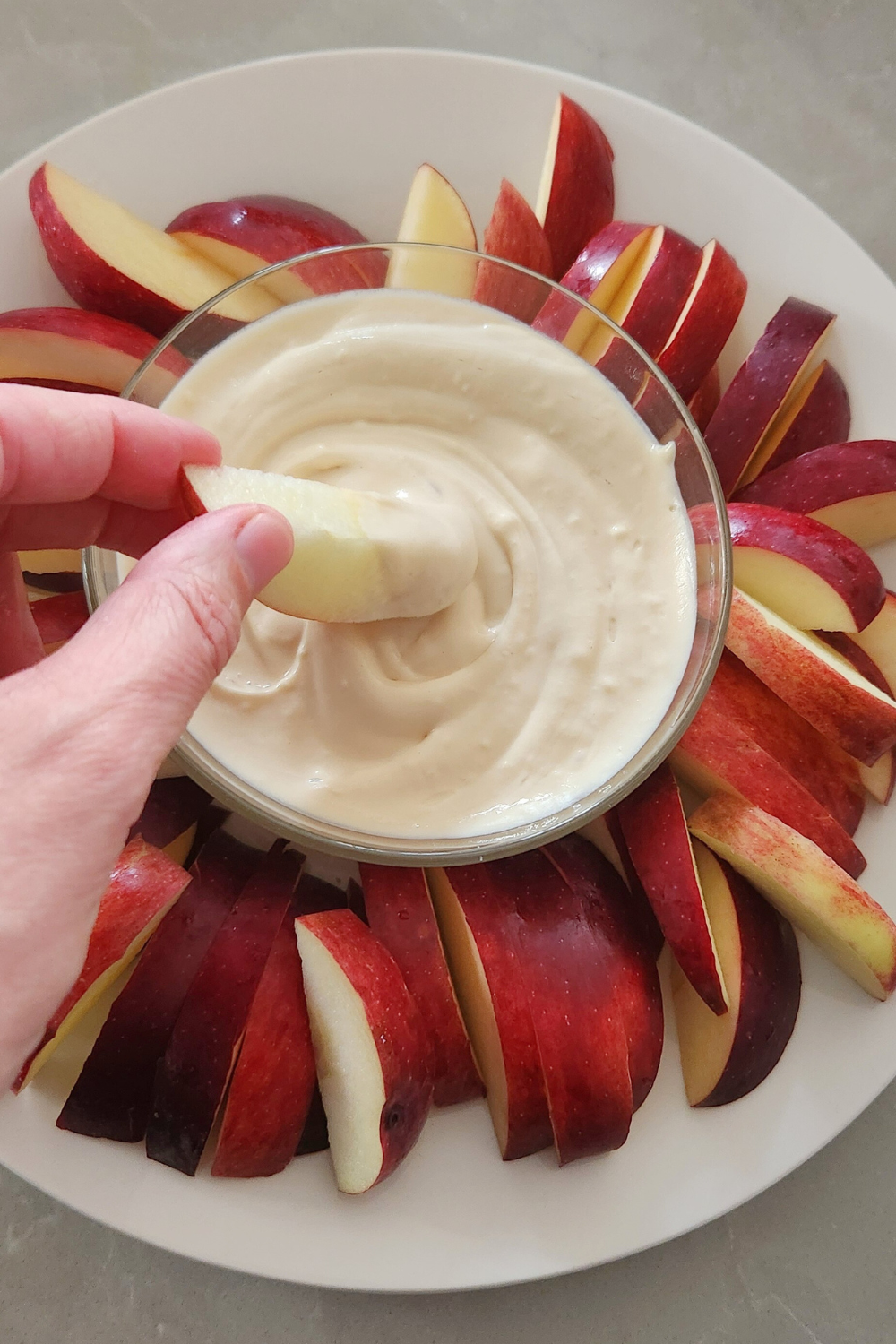 woman dipping apple slice into dip