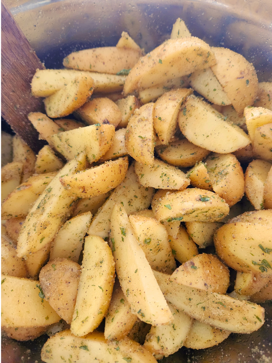 potato wedges for oven fries cut up in a bowl covered in seasoning 