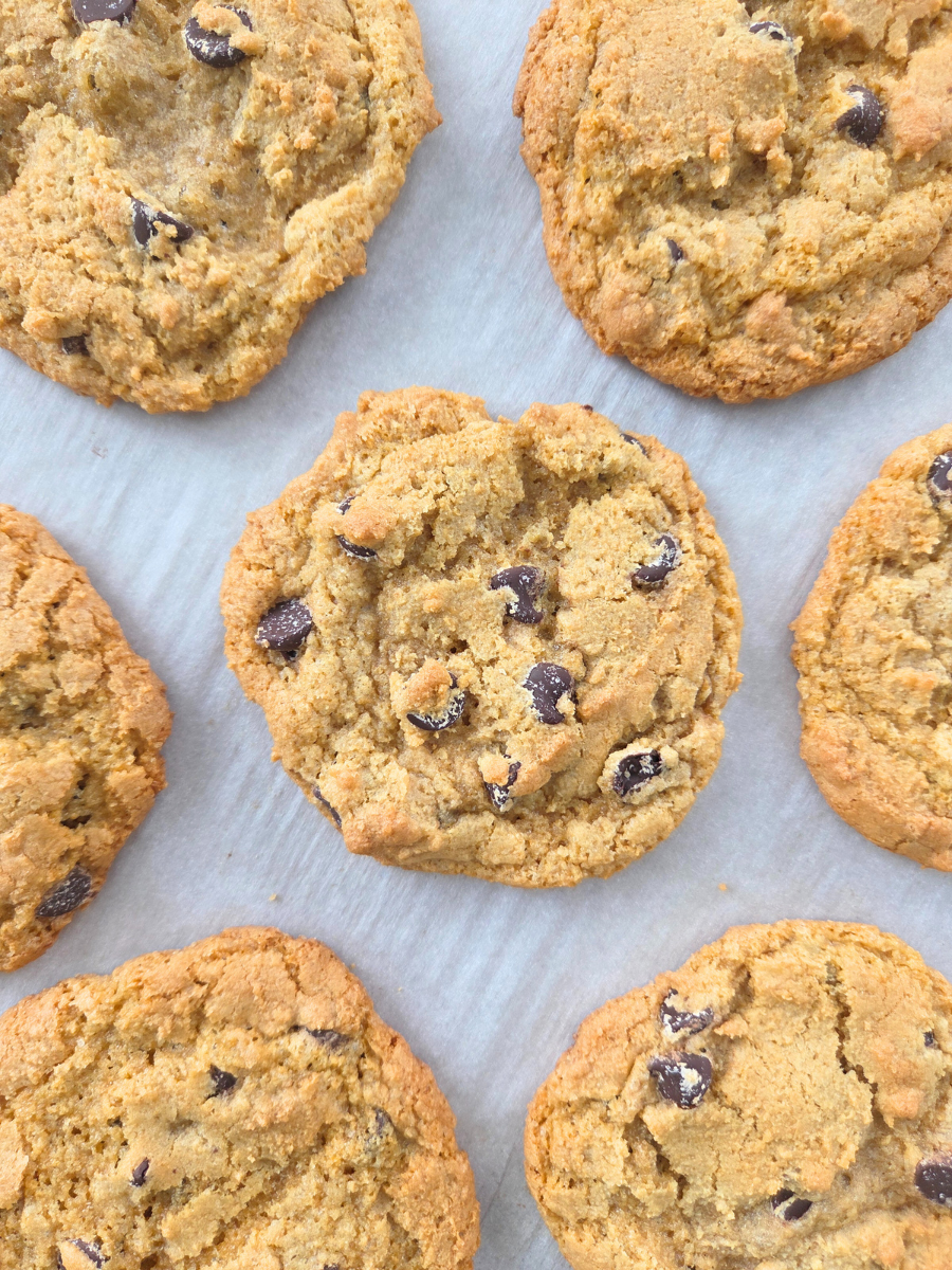 Fresh milled chocolate chip cookies on a cooling rack, highlighting their rustic shape and chewy texture.
