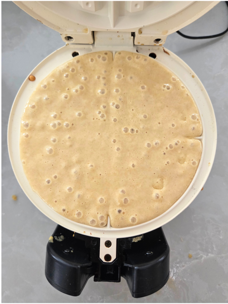 Fresh milled flour waffle batter poured into a waffle iron