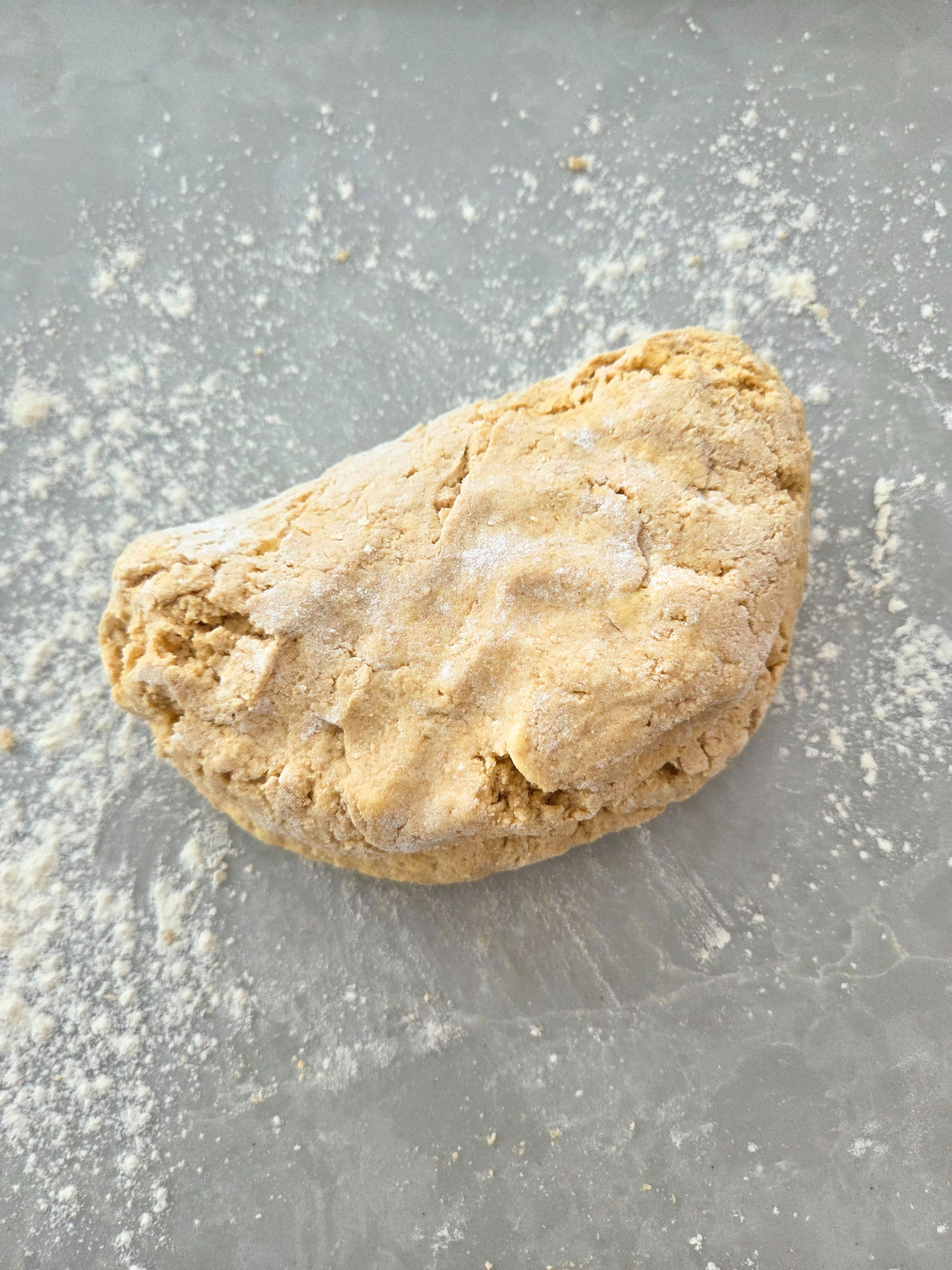 Biscuit dough gathered into a rough ball on a lightly floured countertop