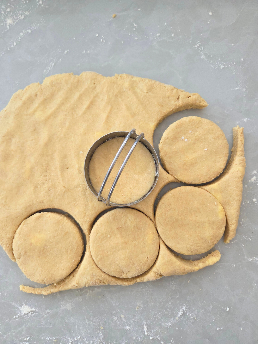 Biscuit dough rolled out and cut into rounds using a biscuit cutter