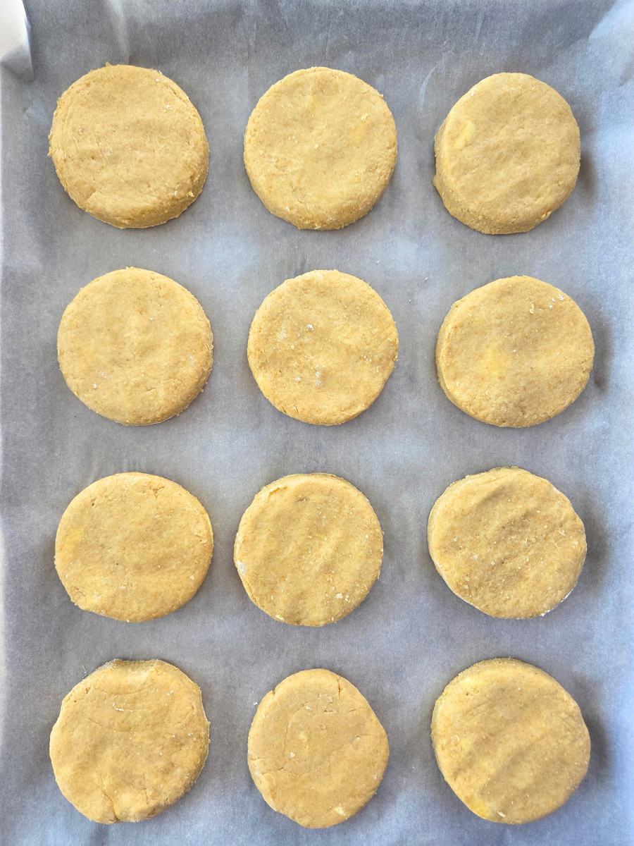 Unbaked fresh milled flour biscuits arranged on a parchment-lined baking sheet
