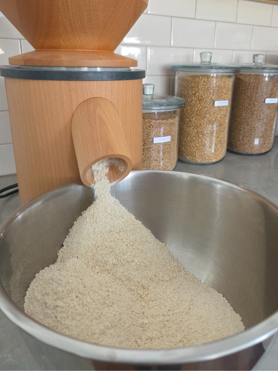 Fresh milled soft white wheat flour being milled directly into a mixing bowl