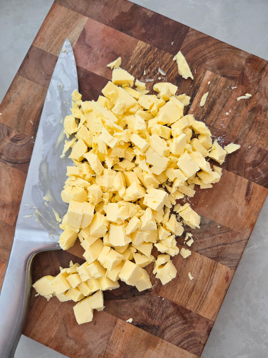 Cold butter chopped into small pieces on a cutting board for making biscuits