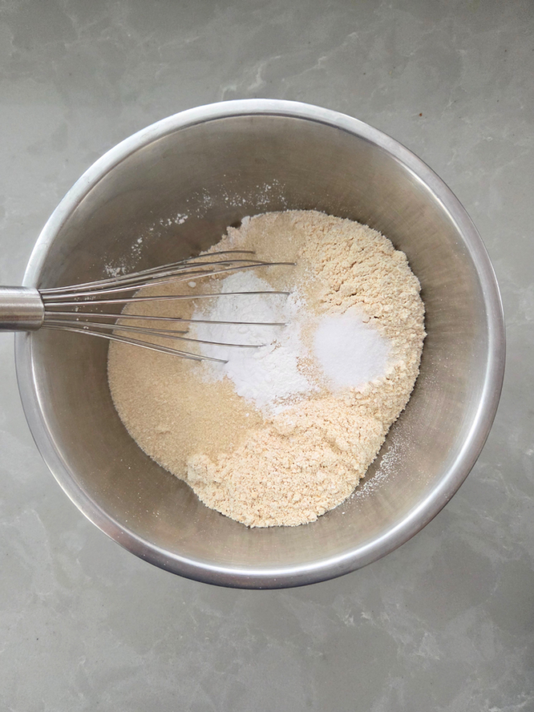 Fresh milled flour, baking powder, baking soda, salt, and sugar whisked together in a metal mixing bowl.