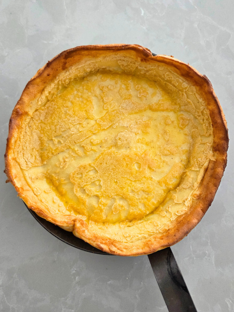 Fresh milled flour Dutch baby pancake baked in a cast iron skillet, puffed and golden