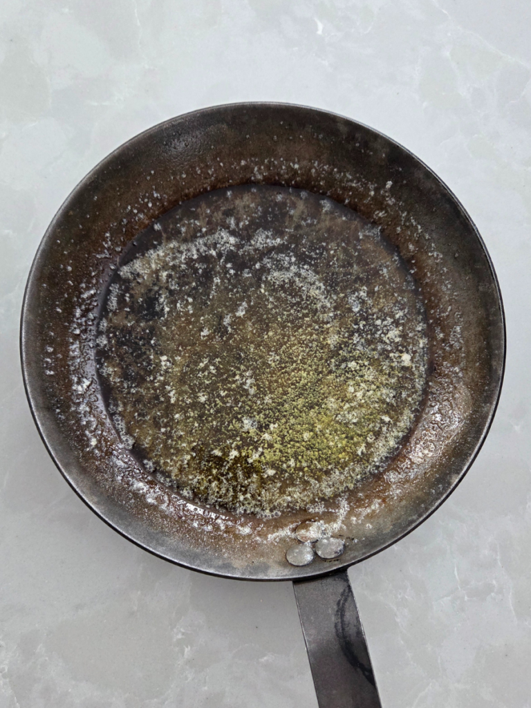 Melted butter in a preheated cast iron skillet for making a Dutch baby pancake