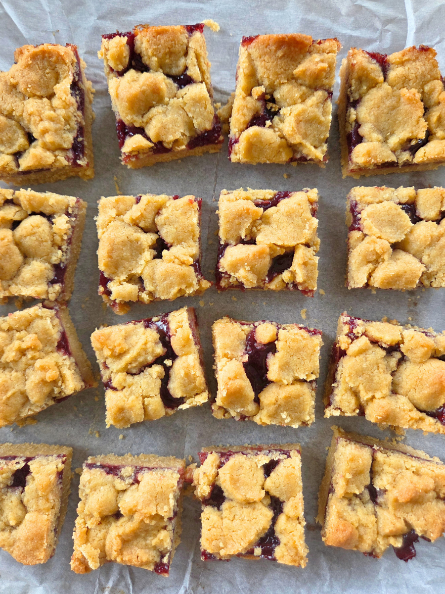 Overhead view of fresh milled flour jam bars arranged on parchment paper after baking.