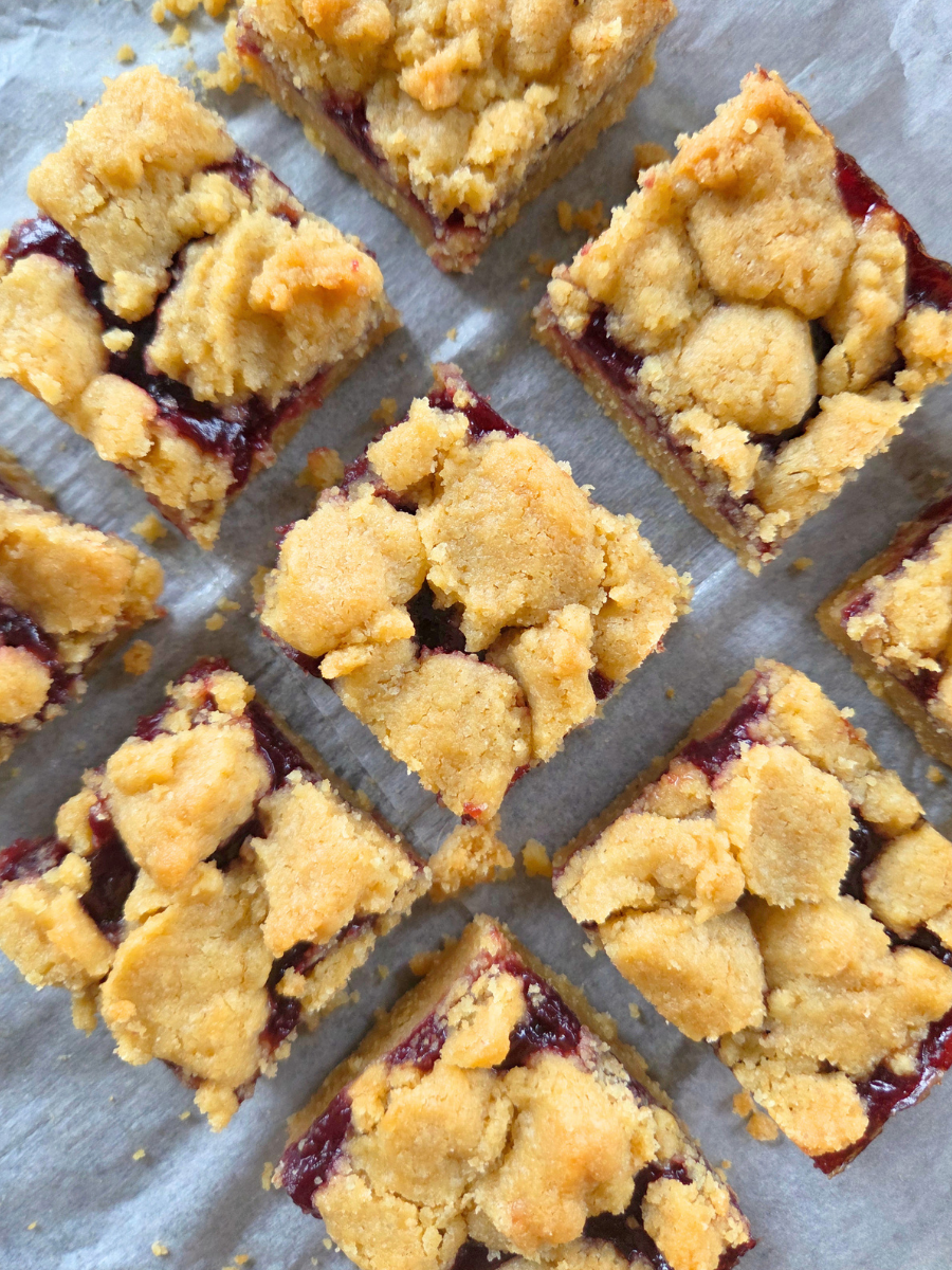 Close-up of fresh milled flour jam crumble bars with golden crumb topping and thick homemade jam layer.