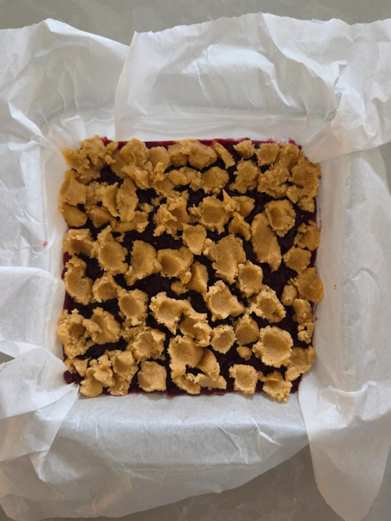 Crumble topping added over jam layer before baking