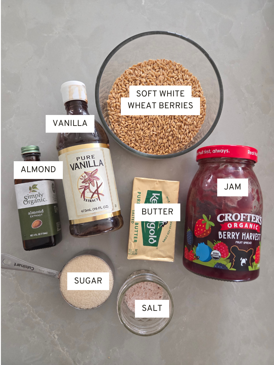 Ingredients for fresh milled flour jam bars including soft white wheat berries, butter, sugar, jam, vanilla, almond extract, and salt.