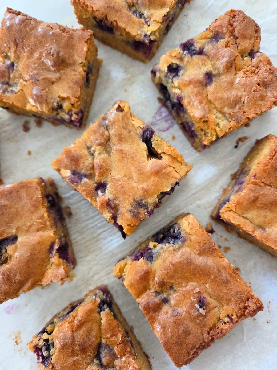 Freshly milled flour blueberry blondies cut into squares with golden tops and blueberry-filled centers.