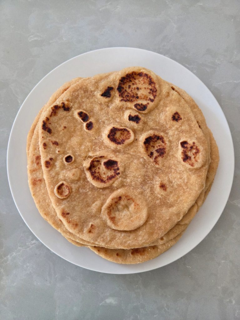 Stack of homemade freshly milled flatbread cooked in a skillet until golden brown and lightly puffed.