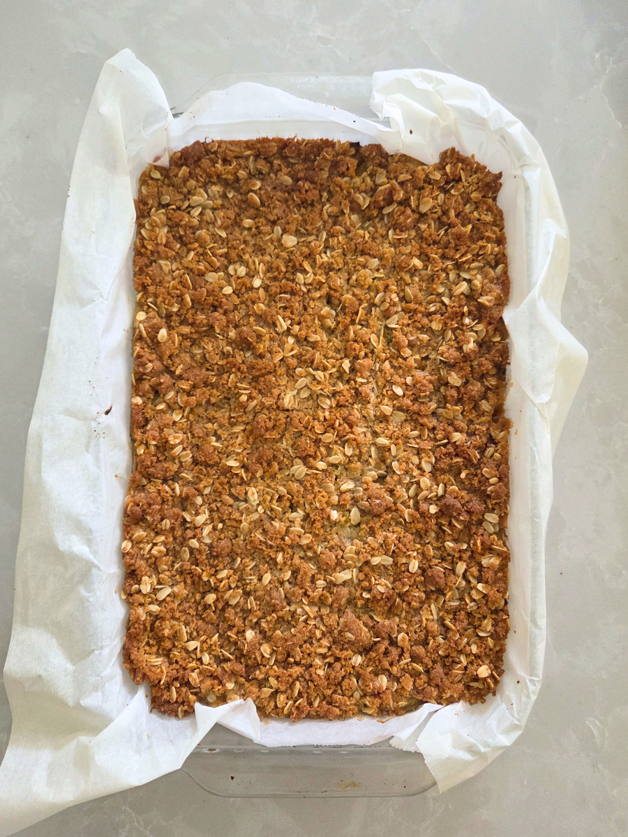Fresh Milled Flour Rhubarb Crumble Bars baked until golden brown in a parchment-lined baking pan.
