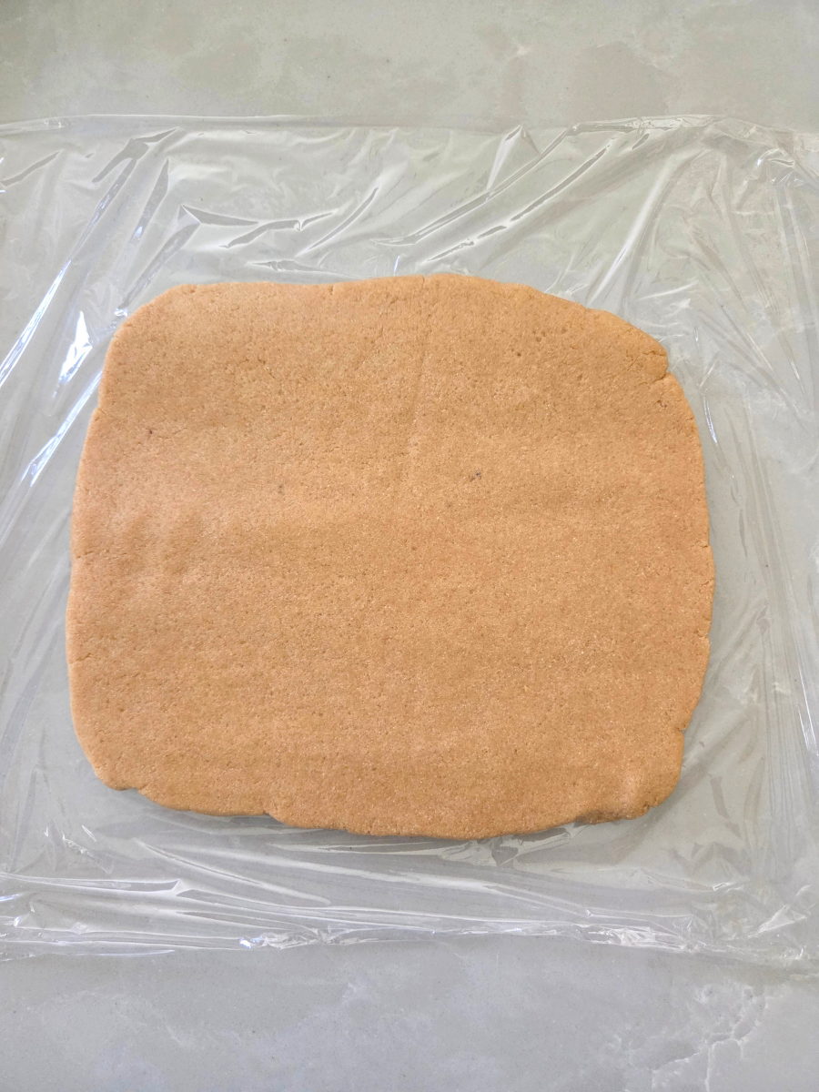 Graham cracker dough shaped into a flat rectangle before chilling