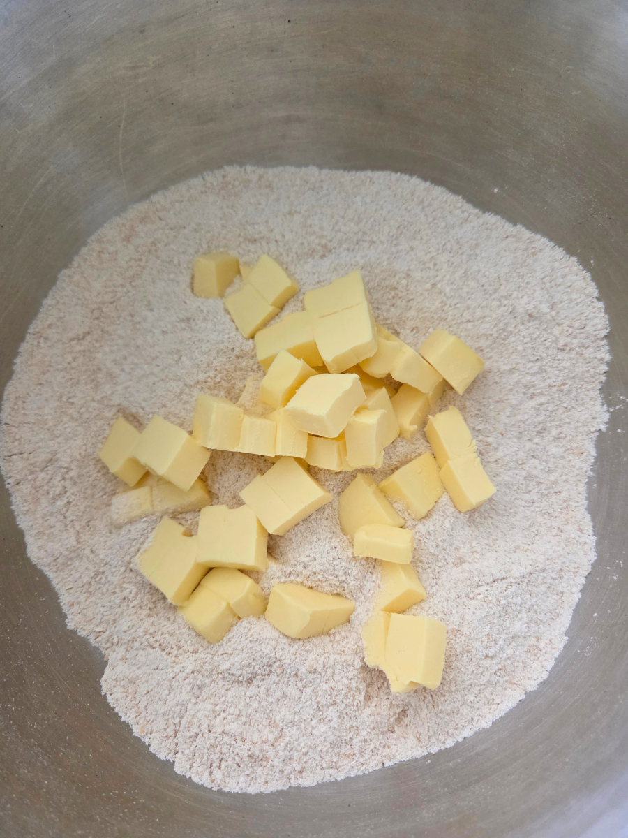 Cold butter cubes added to freshly milled flour mixture for homemade shortcakes.