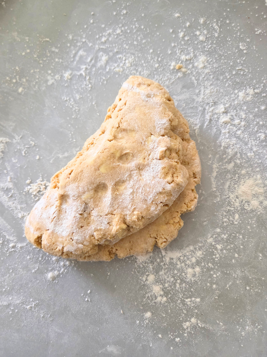 Folding biscuit dough by hand to create light flaky layers.