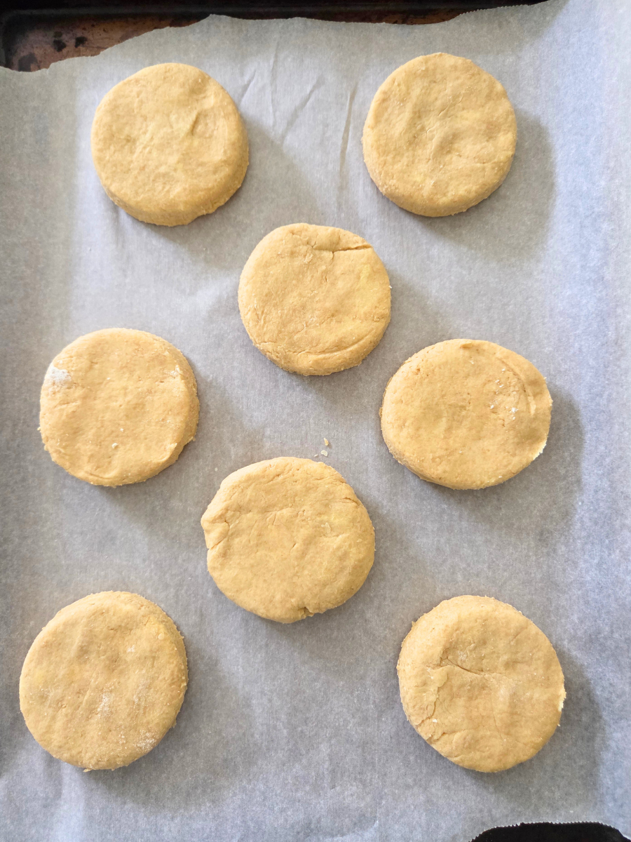 Shortcake biscuits placed on a parchment lined baking sheet before going into the oven.