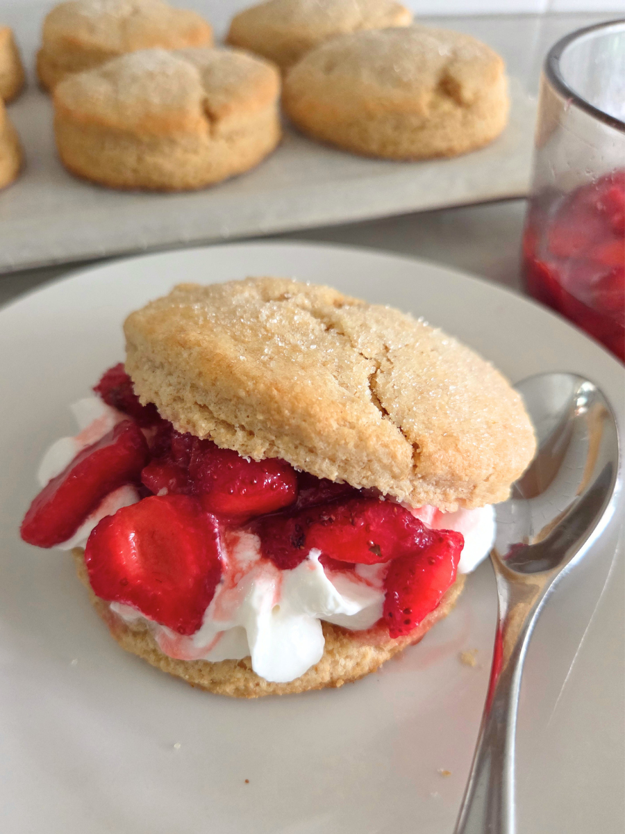 Biscuit-style fresh milled flour strawberry shortcake served with sweet strawberries and whipped cream.