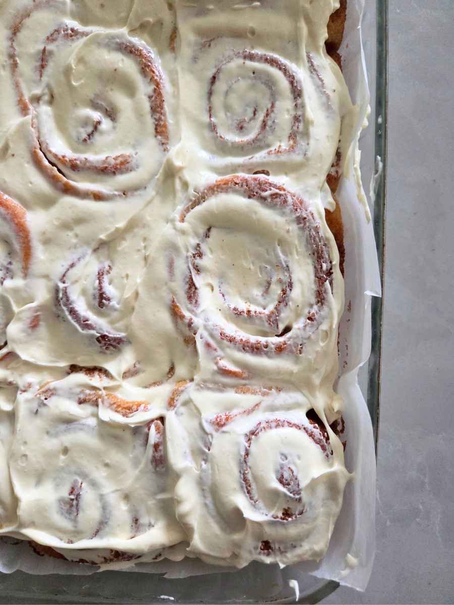 Close-up of homemade fresh milled flour cinnamon rolls topped with cream cheese frosting.