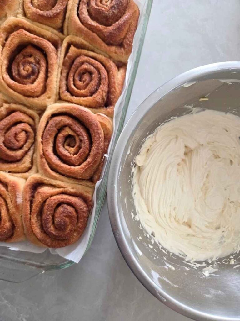 Cream cheese frosting prepared for freshly baked cinnamon rolls.