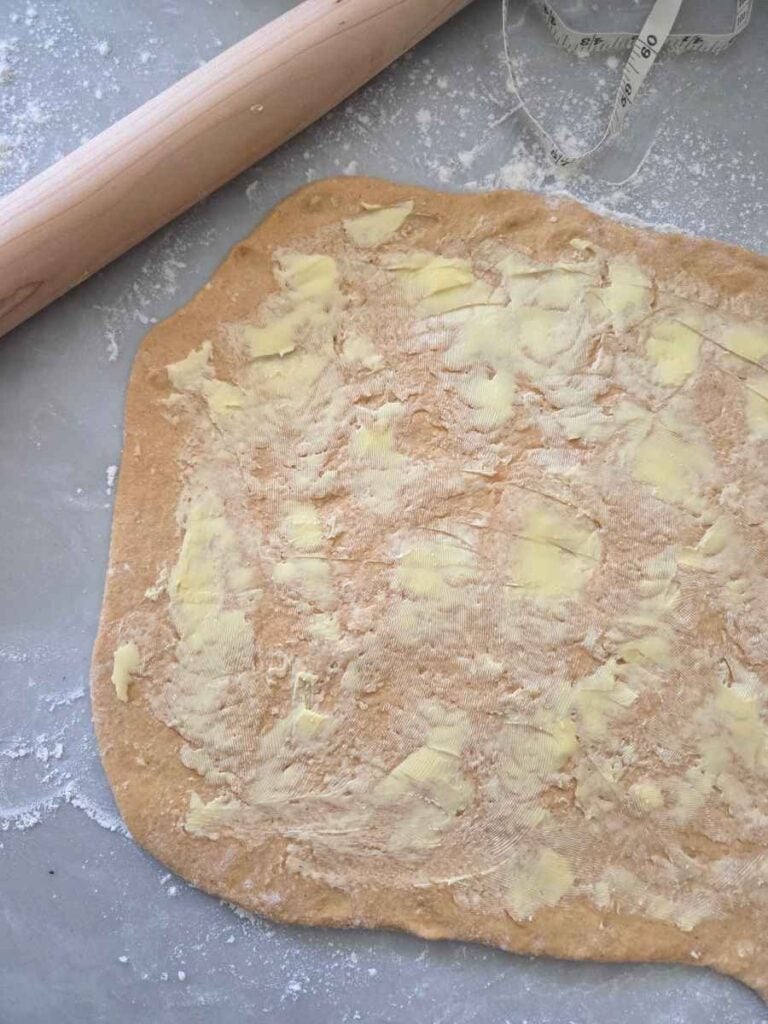 Softened butter spread over the rolled dough.