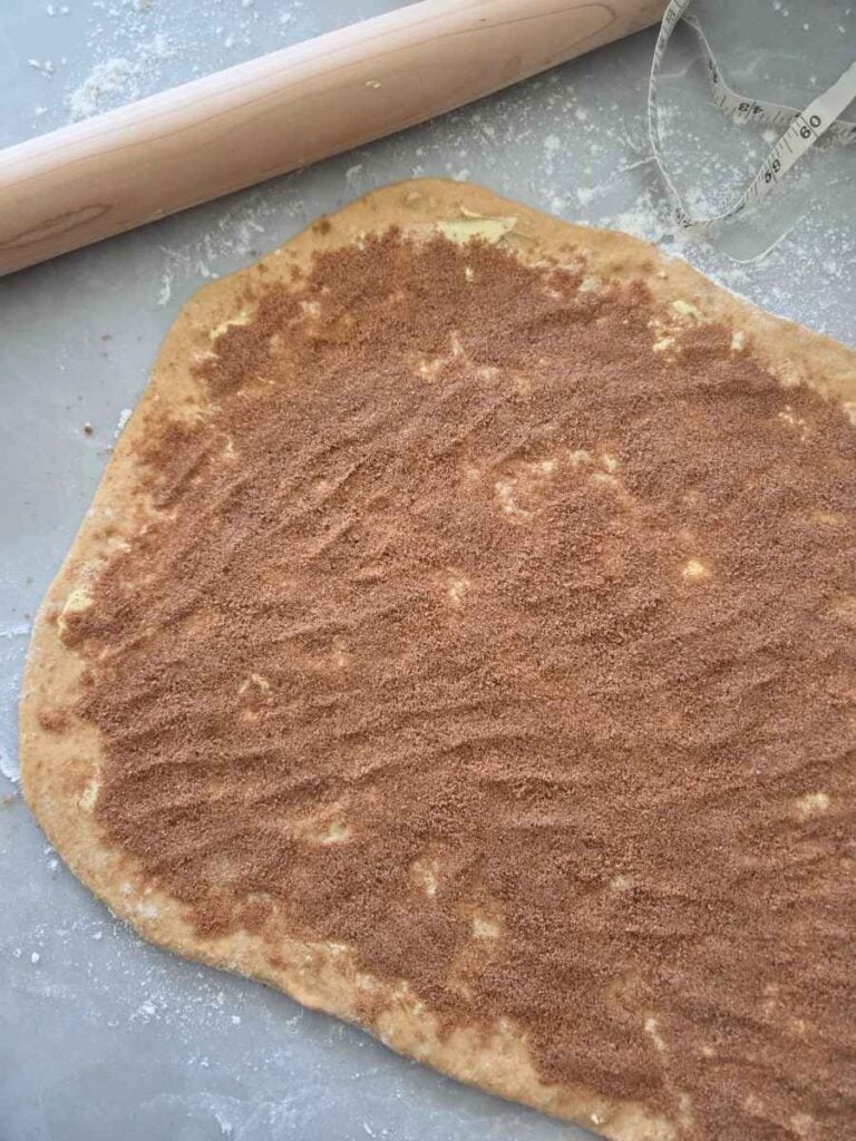 Cinnamon sugar spread evenly over the buttered dough.