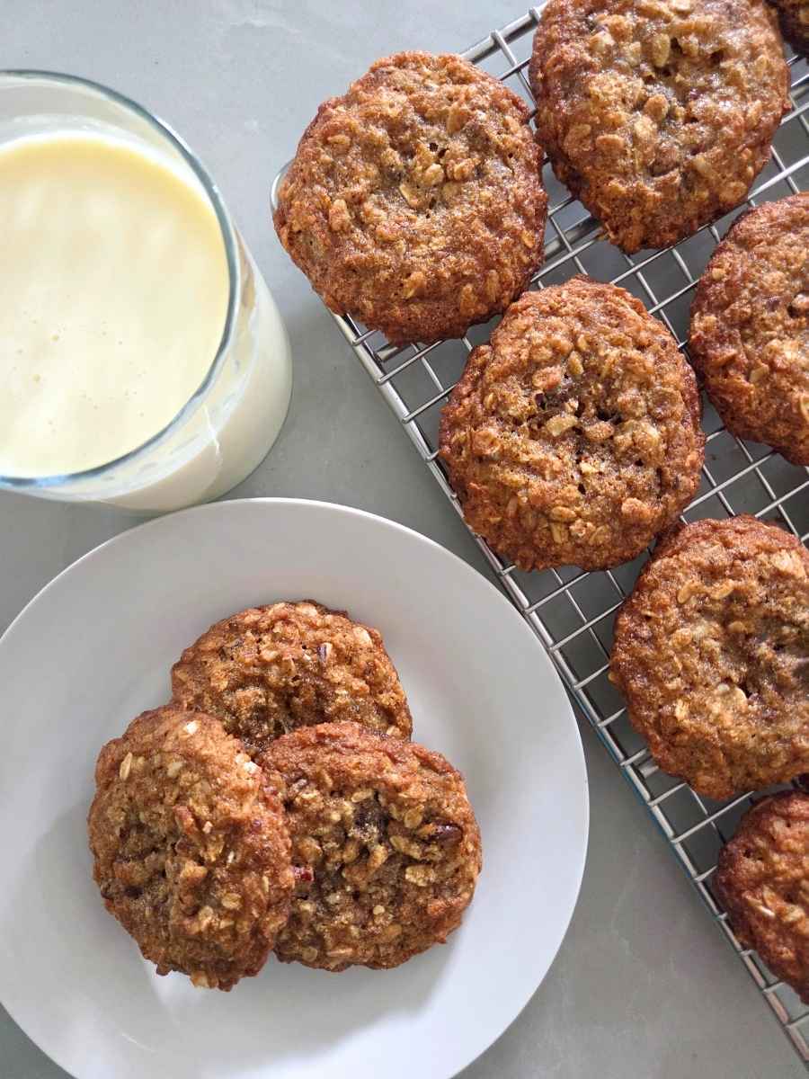 Homemade fresh milled flour cowboy cookies with milk and cookies cooling on a wire rack
