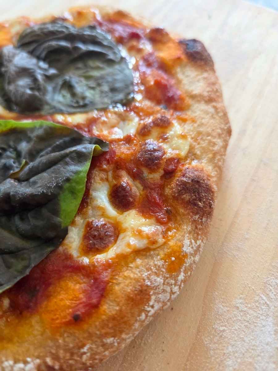Close-up of the crisp, golden crust on a fresh milled flour pizza dough recipe