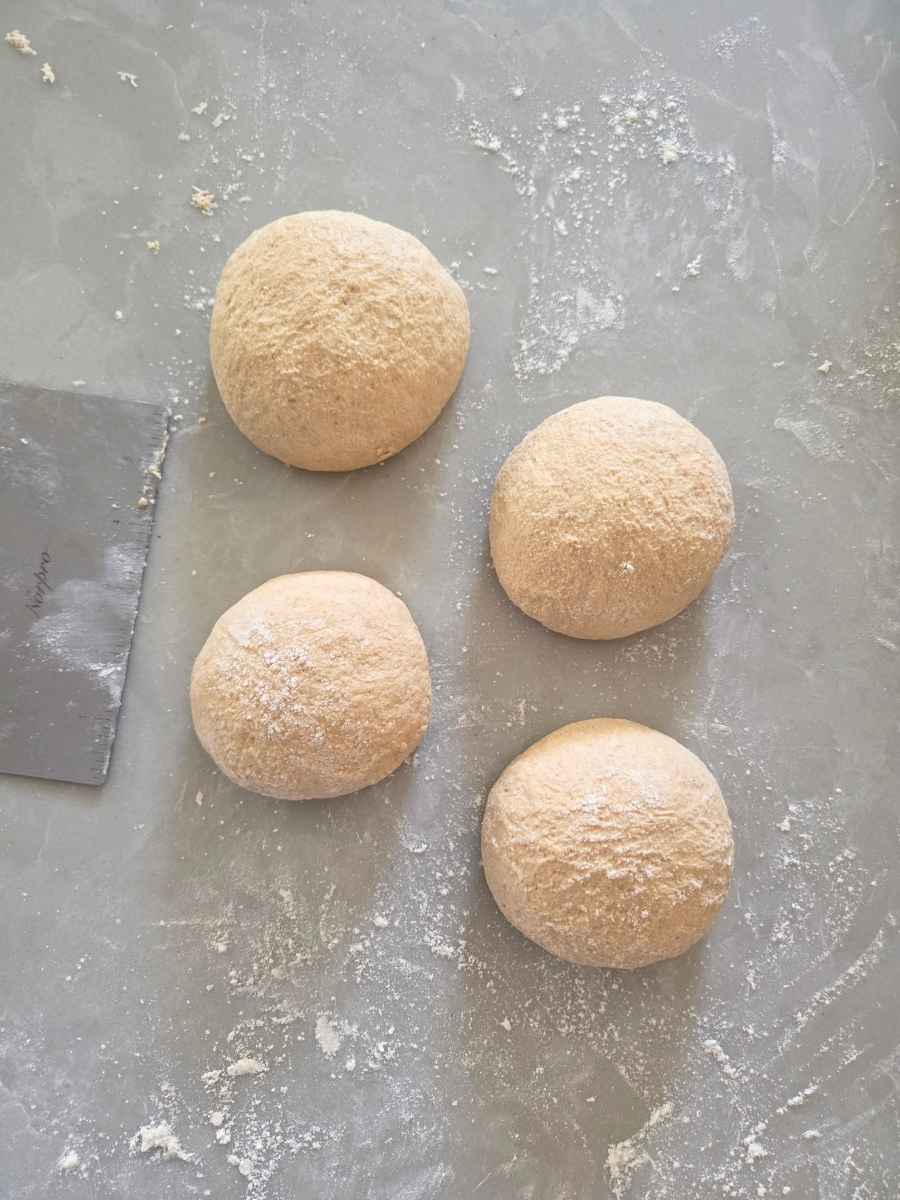 Pizza dough divided and shaped into four equal dough balls