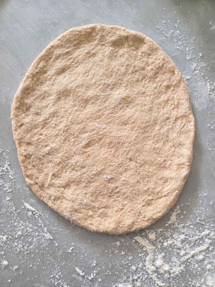Pizza dough gently pressed into a 10-inch round on a floured work surface