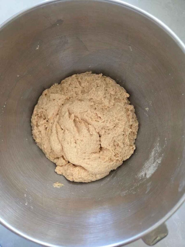 Flour, salt, yeast, and water being mixed together to make pizza dough