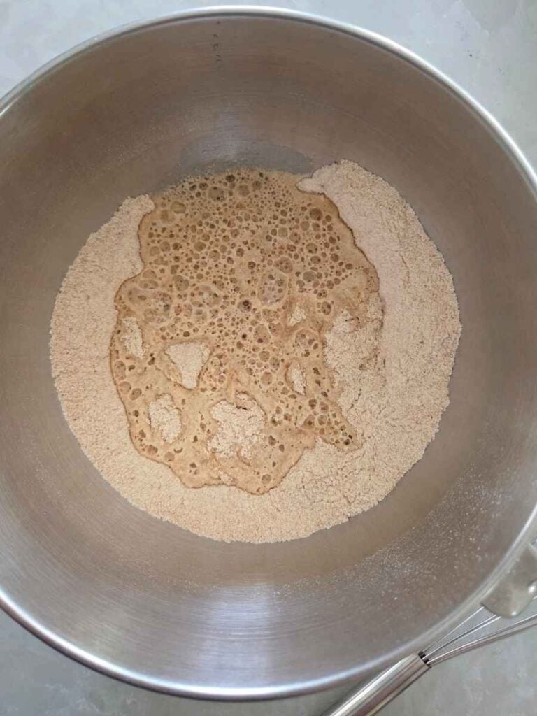 Fresh milled flour, salt, yeast, and water in a bowl to make pizza dough