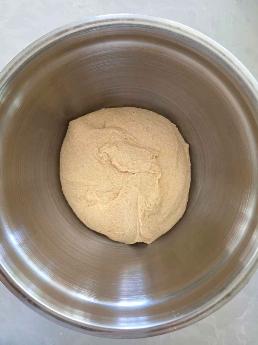 Smooth pizza dough in a mixing bowl after kneading