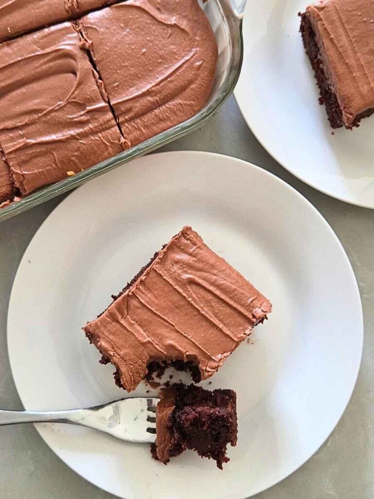 Chocolate zucchini cake made with freshly milled flour with a bite removed, showing the moist brownie-like crumb.