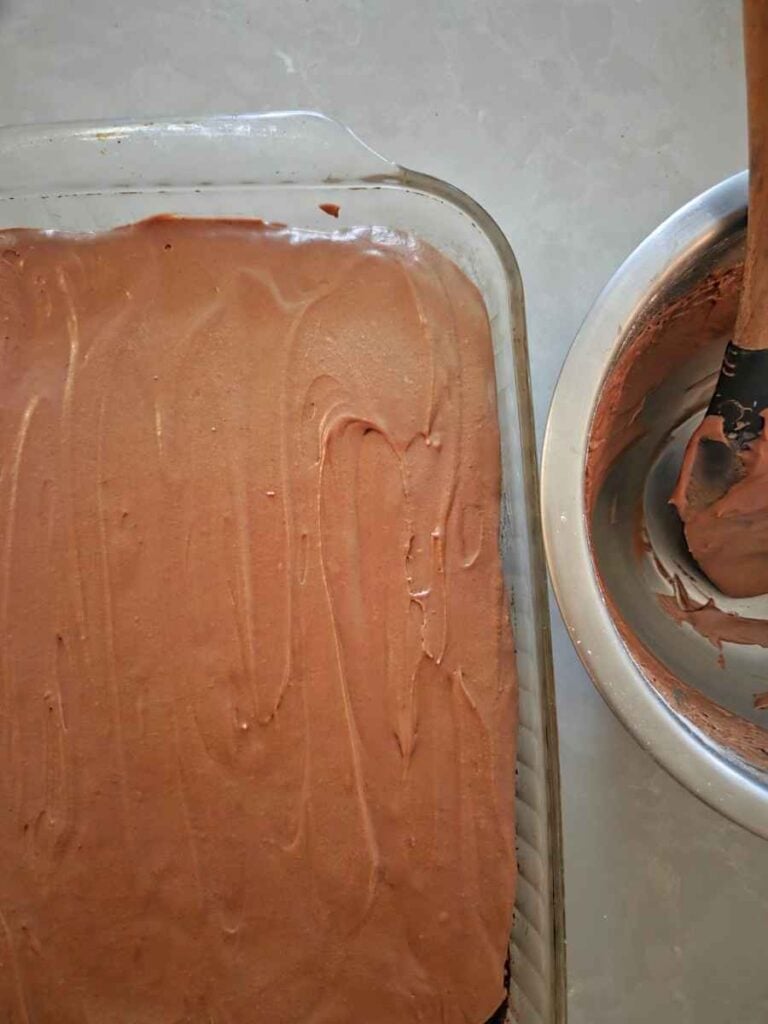Chocolate zucchini cake topped with a smooth layer of homemade chocolate frosting.