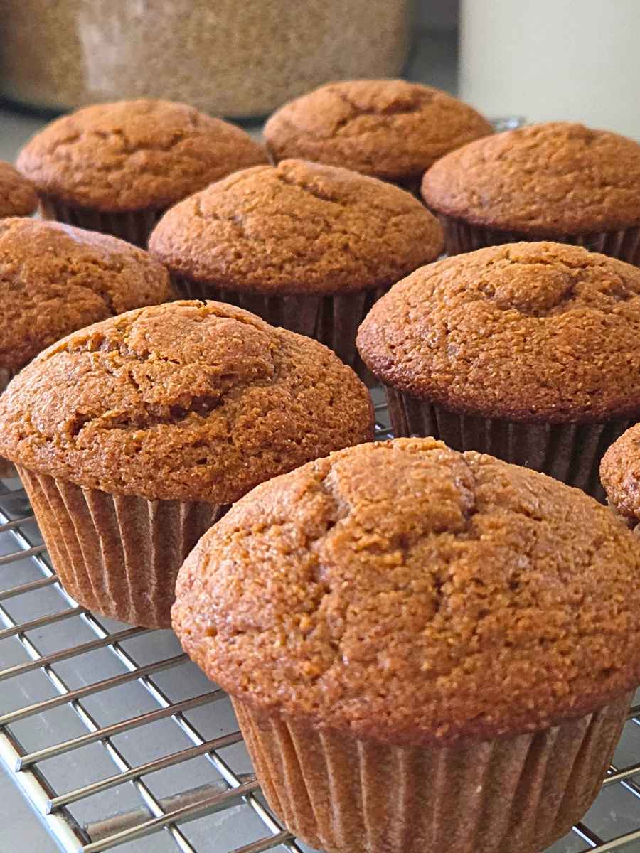 Fresh milled flour pumpkin muffins cooling on a wire rack after baking.