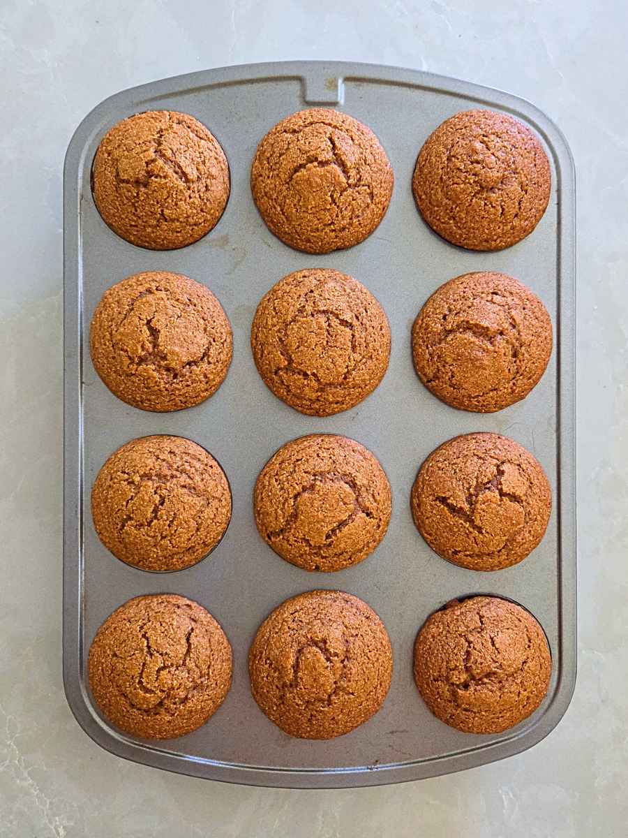 Fresh milled flour pumpkin muffins freshly baked in a muffin pan.