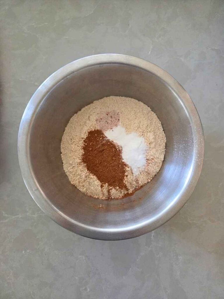 Freshly milled flour, pumpkin spice, baking soda, baking powder, and salt in a mixing bowl.