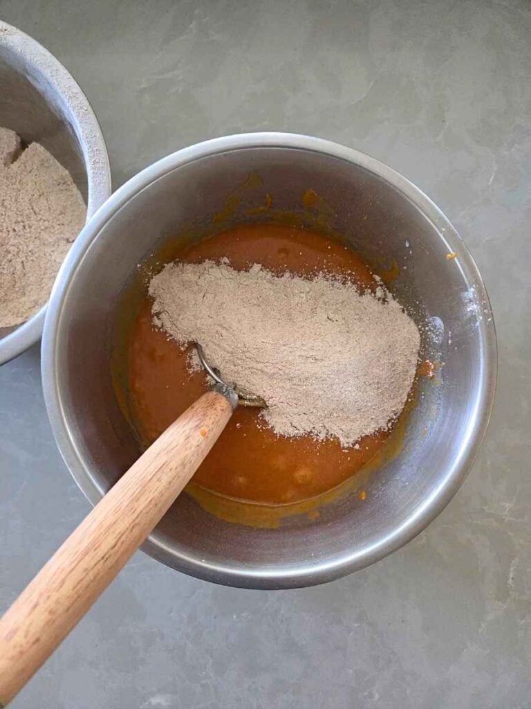 Dry ingredients being added to the pumpkin mixture.