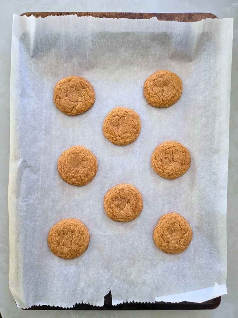 Soft pumpkin snickerdoodle cookies baked until lightly golden on a parchment-lined baking sheet.