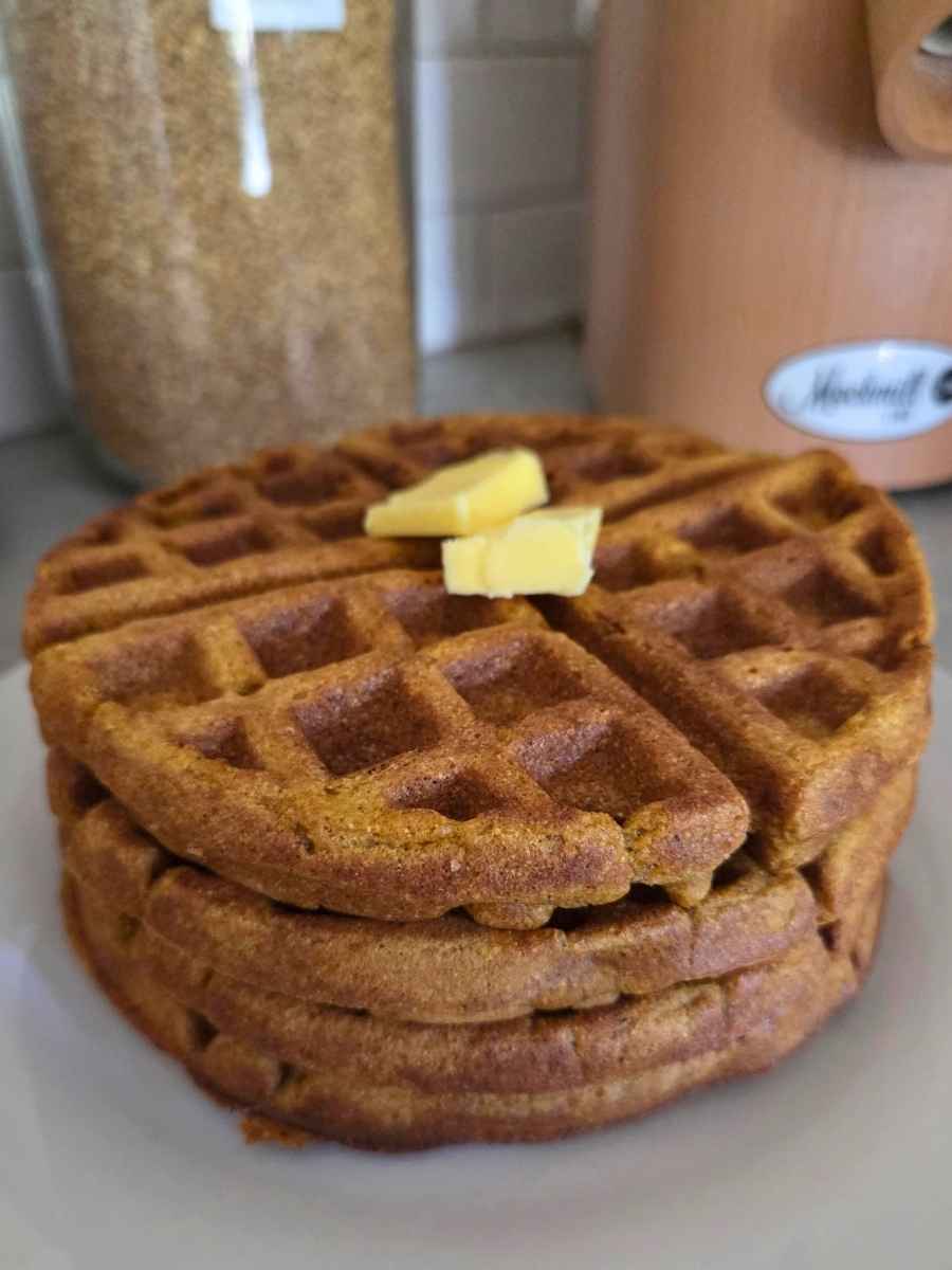 Stack of homemade pumpkin waffles topped with butter