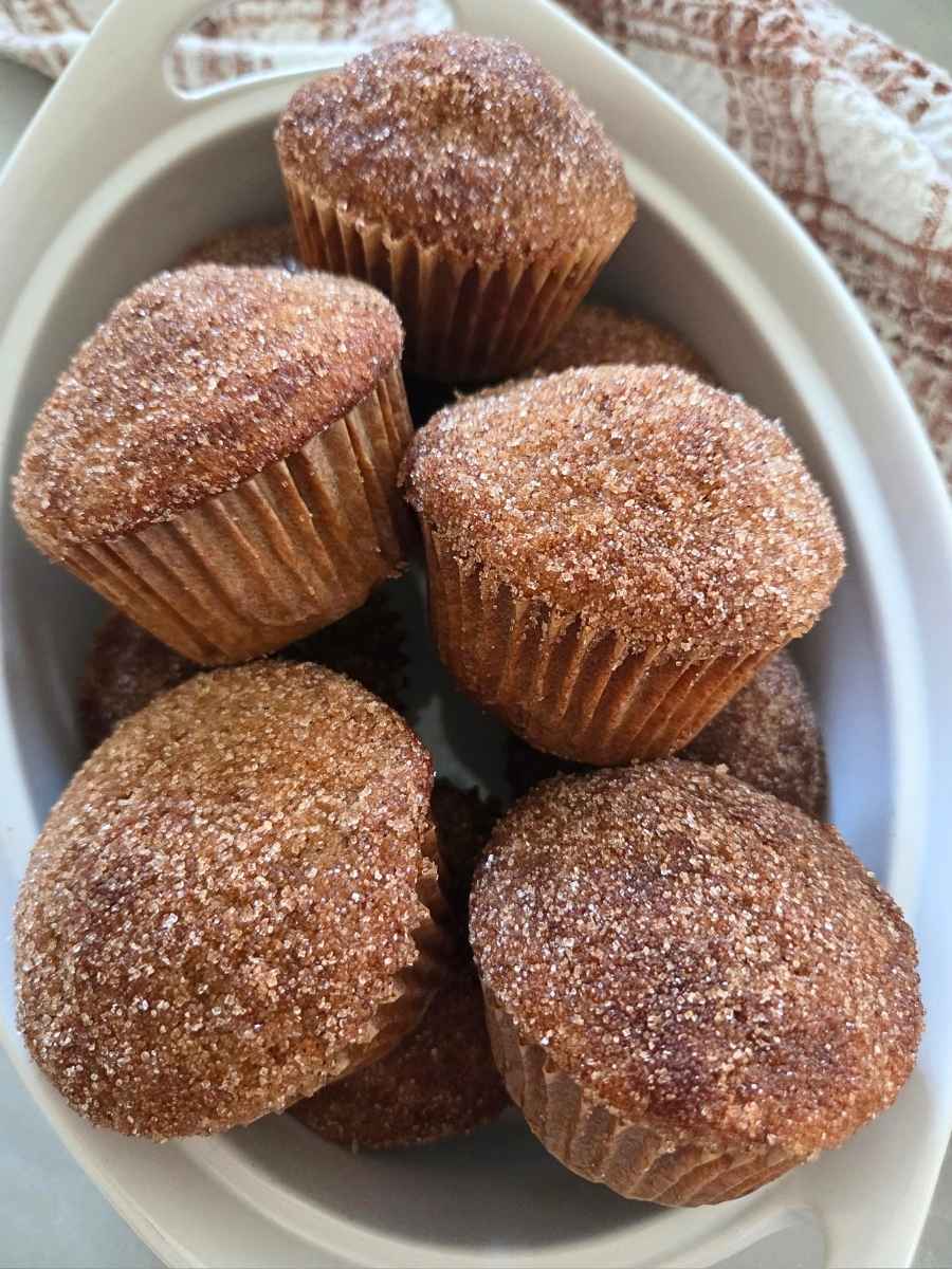 Cinnamon sugar fresh milled flour apple cider donut muffins piled in a white serving dish