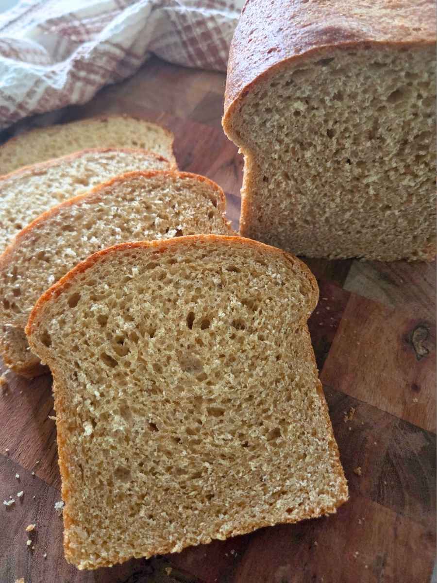 Close-up of sliced fresh milled flour sandwich bread showing its soft, airy crumb and golden crust.
